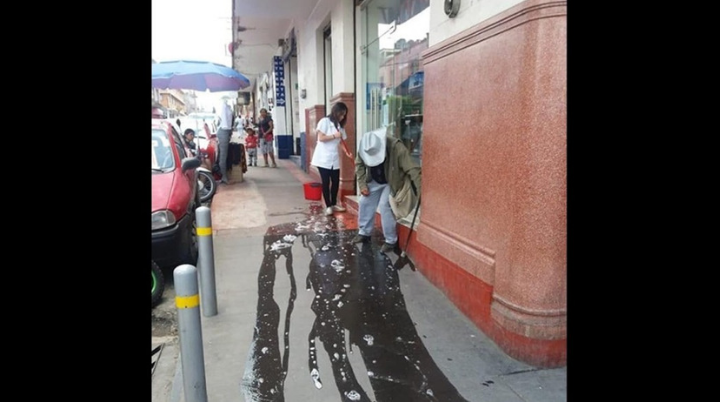 Empleada de una óptica arroja agua a un anciano para correrlo